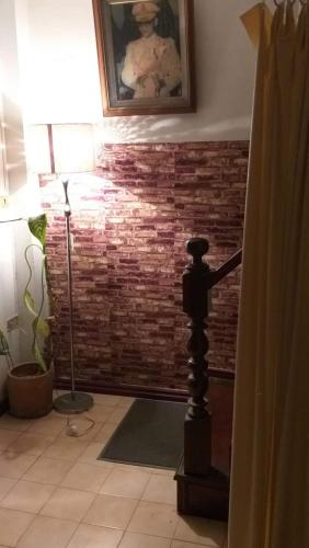 a living room with a brick wall and a lamp at Srikrung Guesthouse in Phra Nakhon Si Ayutthaya
