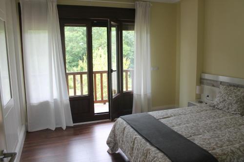 une chambre avec un lit et une grande fenêtre dans l'établissement El Limonero de Pría - Casa Vacacional, à La Pesa