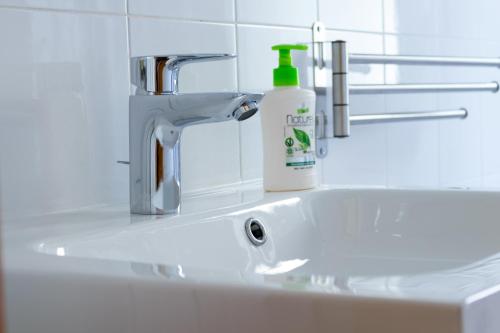 a bathroom sink with a bottle of soap on it at Rivela case vacanze in Ginosa Marina