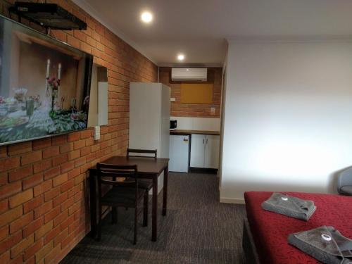 a small room with a table and a kitchen at Travellers Inn Kaniva in Kaniva