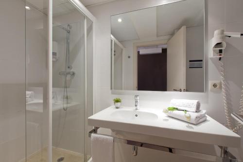 uma casa de banho branca com um lavatório e um chuveiro em Hotel Sagrada Familia em Barcelona