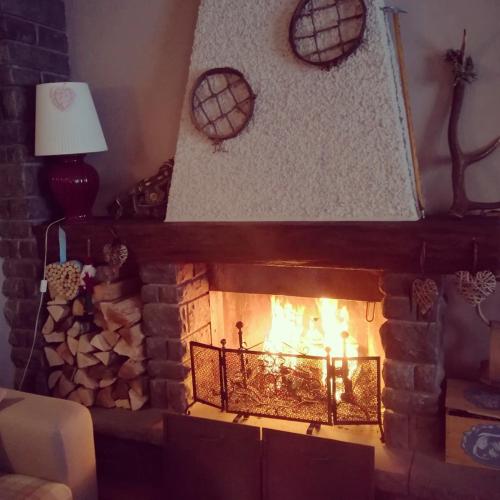 a fireplace in a living room with a fire at Hotel Bristol in Fiumalbo