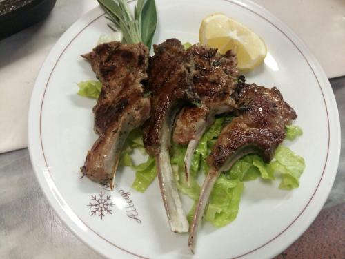 a plate of food with meat on lettuce and a lemon at Hotel Bristol in Fiumalbo