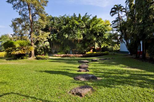 a garden with rocks in the grass at Charoen Hotel in Udon Thani
