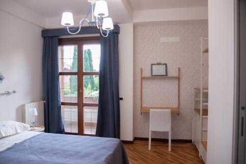a bedroom with a blue bed and a window at Boutique Villa Etna d'A'mare in Trecastagni