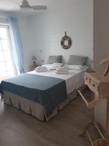 a bedroom with a large bed and a chair at Laura e Christian - Rooms in Grado