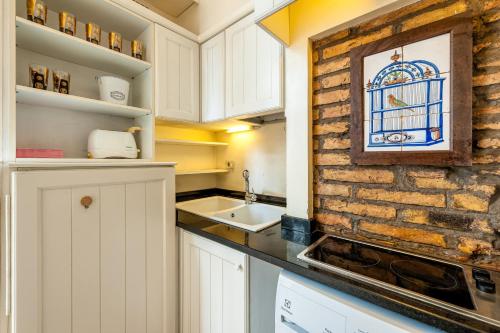 eine Küche mit weißen Schränken und einer Ziegelwand in der Unterkunft IREX Piazza Navona private Cozy apartment in Rom
