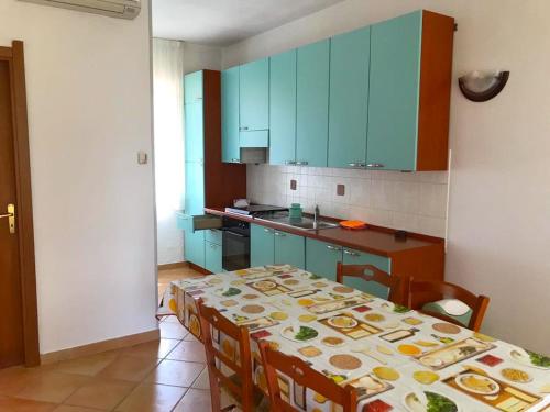 een keuken met een tafel met stoelen en blauwe kasten bij Residence Cassiodoro in Stalettì