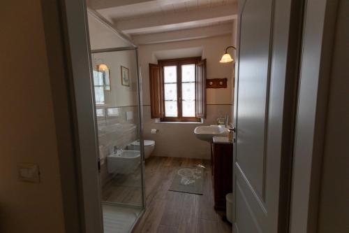 een badkamer met een toilet, een wastafel en een spiegel bij Vista Lago in Torre del Lago Puccini