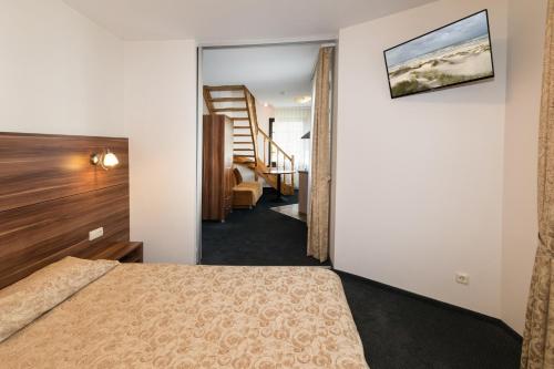 a hotel room with a bed and a staircase at Guest House & Villa Astoma in Palanga