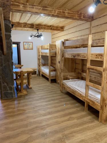 a room with four bunk beds and a table at Zbojnicky penzion in Oravska Jasenica