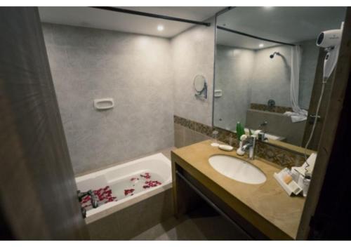 a bathroom with a sink and a bath tub at Neelam's The Grand Hotel Goa in Calangute