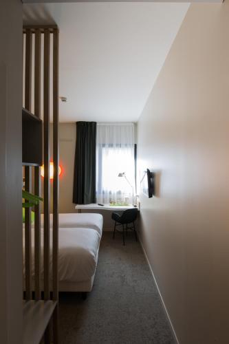 a hotel room with two beds and a window at Campanile Rennes Centre - Gare in Rennes