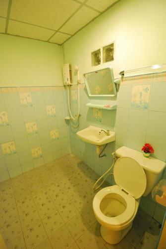 a bathroom with a toilet and a sink at Boathouse Resort Suanphung in Suan Phung