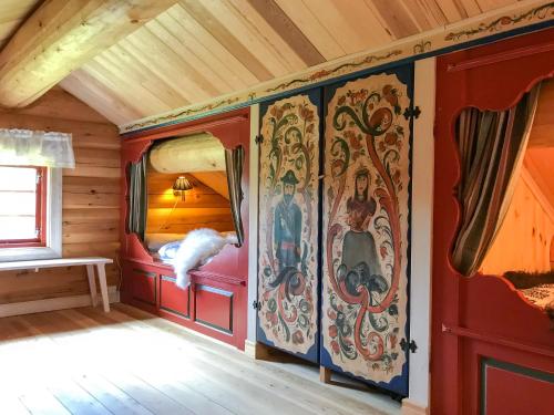una habitación en una cabaña con pinturas en las paredes en Tjonnas Farm Stay en Sauland