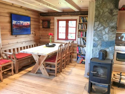 a dining room with a table and a wood stove at Tjonnas Farm Stay in Sauland