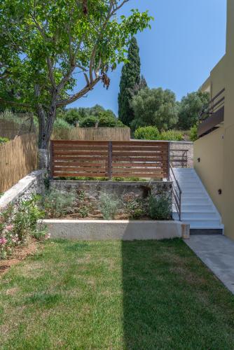 a garden with a wooden fence and a staircase at Diogenis Villa in Argostoli