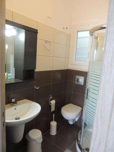 a bathroom with a sink and a toilet at levante studios Αndros in Ménites