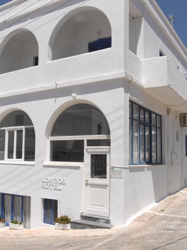 a white building with an archway and a door at Londos Hotel in Piso Livadi