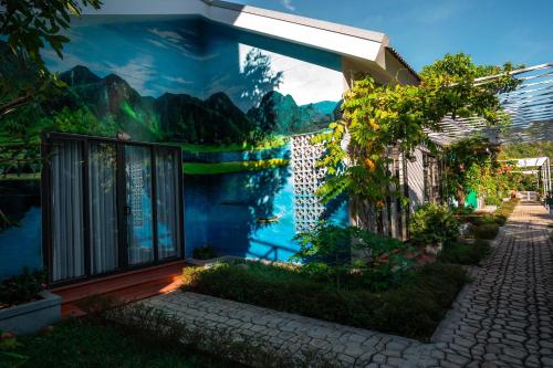 a building with a mural on the side of it at Commander Lodge in Phong Nha