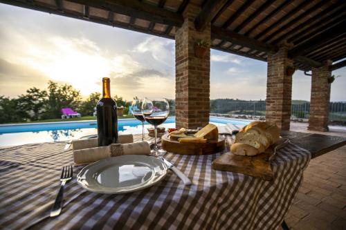 einen Picknicktisch mit einem Glas Wein und Käse in der Unterkunft La Coppa in Asciano