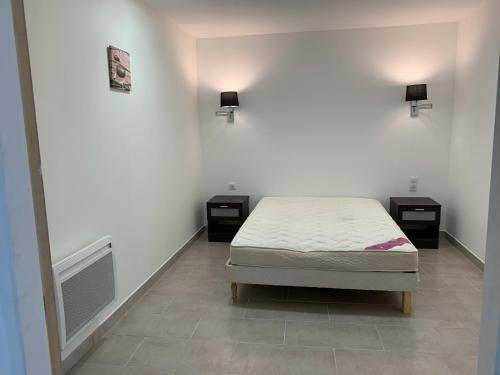 une chambre avec un lit et deux tables de nuit dans l'établissement Appartement corse olmeto, à Olmeto