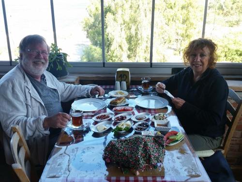 Un uomo e una donna seduti a un tavolo con una torta di Selenes Pansiyon a Kapıkırı