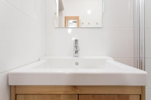 łazienka z białą umywalką i lustrem w obiekcie Vienna Smile Apartment Schoenbrunn w Wiedniu
