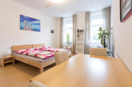sypialnia z łóżkiem, stołem i krzesłami w obiekcie Vienna Smile Apartment Schoenbrunn w Wiedniu