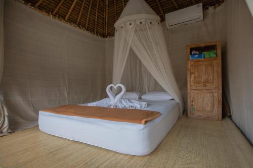 een slaapkamer met een hemelbed bij Salty Shakas Bamboo Stay Canggu in Canggu