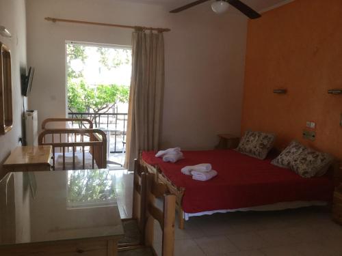 Un dormitorio con una cama roja con toallas. en Hotel Kallithea, en Loutra Edipsou