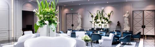 a conference room with blue chairs and plants in it at Boscolo Lyon Hotel & Spa in Lyon