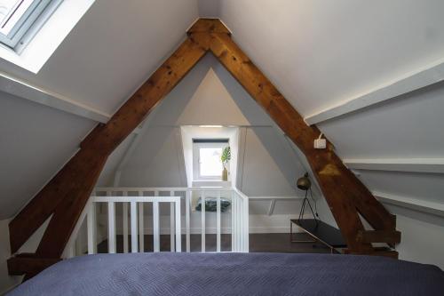 a attic room with a bed and a window at Citystays Deventer in Deventer