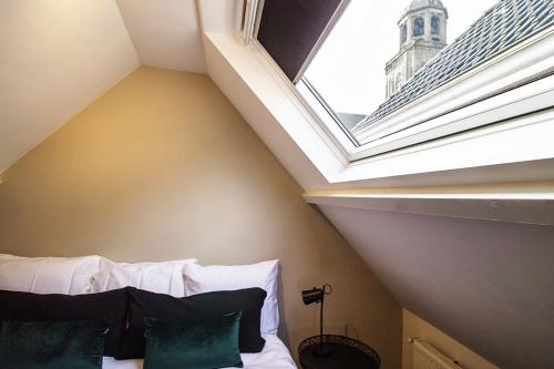 a bedroom with a window and a bed with pillows at Citystays Deventer in Deventer