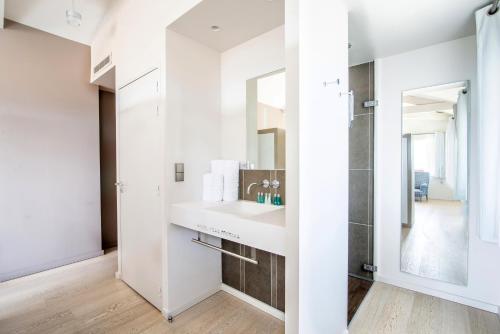 a bathroom with a sink and a mirror at Hotel Itsas Mendia in Bidart