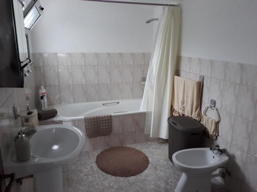 a bathroom with a sink and a tub and a toilet at Casa da Tia Marina in Lajes das Flores