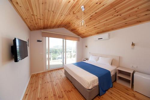 a bedroom with a bed and a flat screen tv at Metins Gümüşlük in Bodrum City