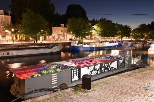 a boat is docked in a river at night at Surprenantes- Le DÔ in Nantes