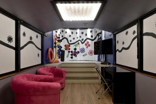 une chambre avec deux chaises, une table et des fenêtres dans l'établissement Surprenantes- Le DÔ, à Nantes