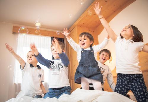 a group of children jumping on a bed at Hotel Siror in Fiera di Primiero