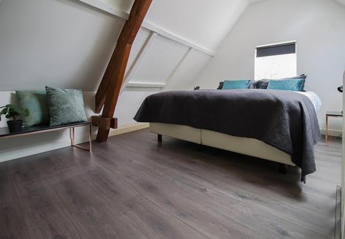 a bedroom with a bed and a wooden floor at Citystays Deventer in Deventer