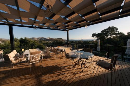eine Terrasse mit Tisch und Stühlen auf einem Deck in der Unterkunft Metins Gümüşlük in Bodrum City