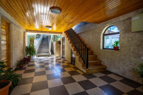 a hallway of a house with a checkered floor at Guesthouse David Zhorzholiani in Mestia
