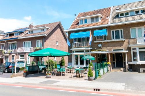 a green and white building with a blue umbrella at Hotel het Anker in Valkenburg