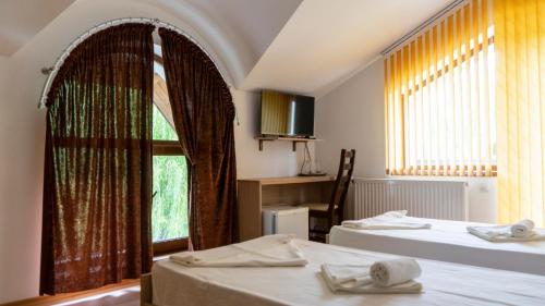 a room with two beds and a window at Califarul Alb in Chilia Veche