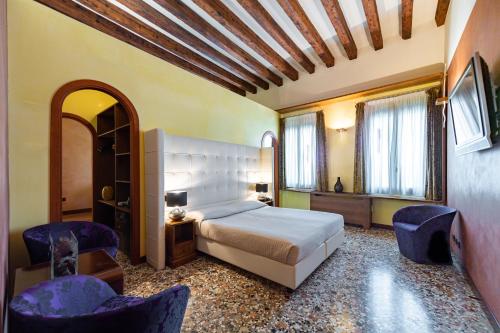 1 dormitorio con 1 cama y 2 sillas en Abbazia De Luxe en Venecia