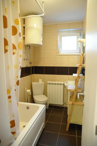 a bathroom with a tub and a toilet and a sink at Apartment A in Belgrade
