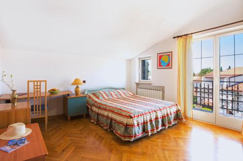 1 dormitorio con cama, escritorio y ventana en Villa Sveta Eufemija - Bed and breakfast, en Rovinj