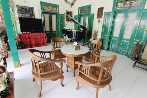 a room with a table and chairs and a television at Pendopo Andari Homestay in Yogyakarta