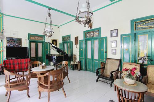a living room filled with furniture and a piano at Pendopo Andari Homestay in Yogyakarta